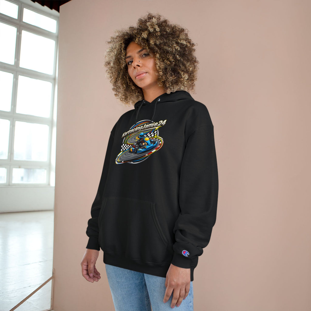 Frau mit einer schwarzen kartracing champion hoodie, die eine dynamische Grafik zeigt und Rennstrecken-Energie ausstrahlt.