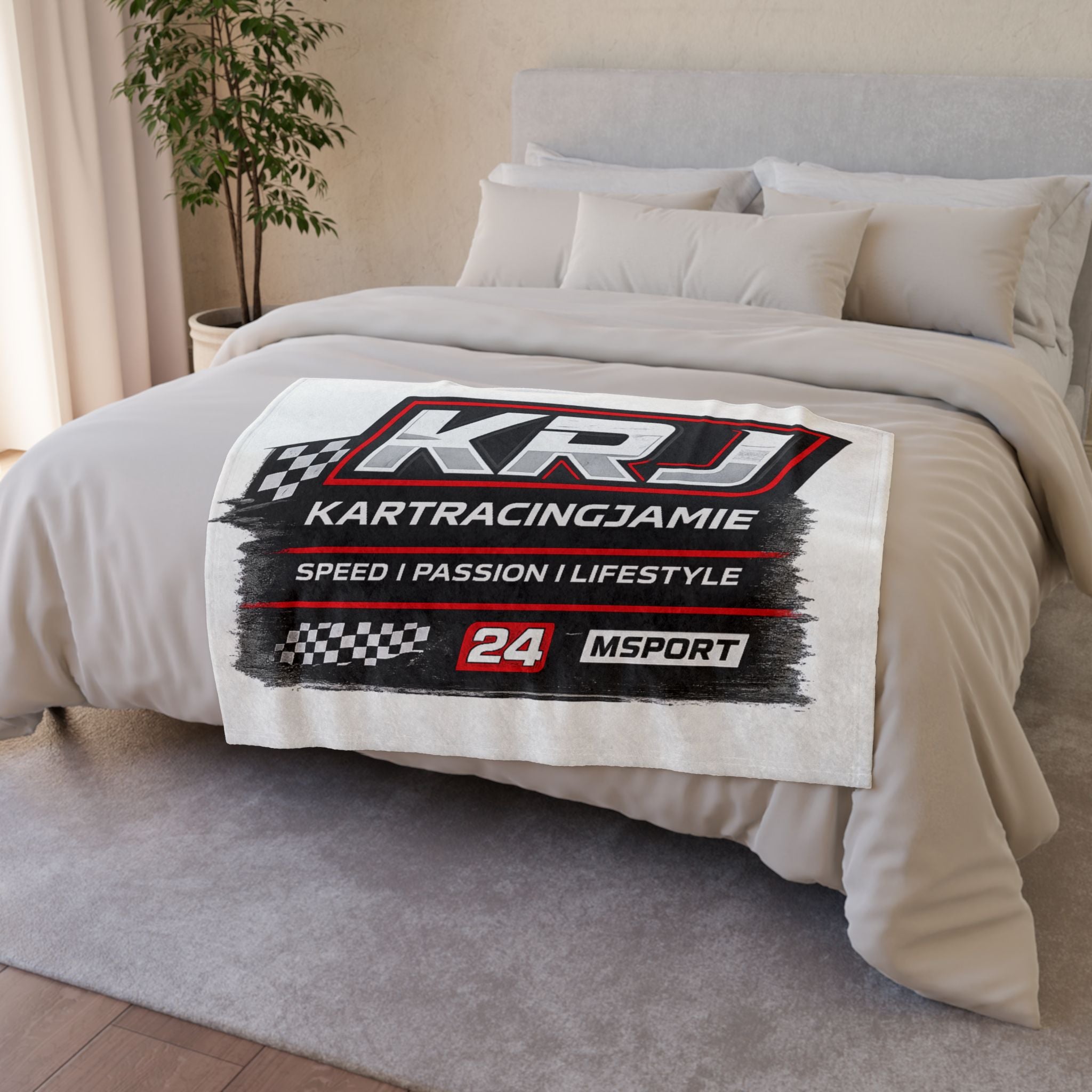 KRJ Kart Racing Blanket mit schachbrettförmigen Flaggen und kraftvollen Grafiken auf einem Bett.